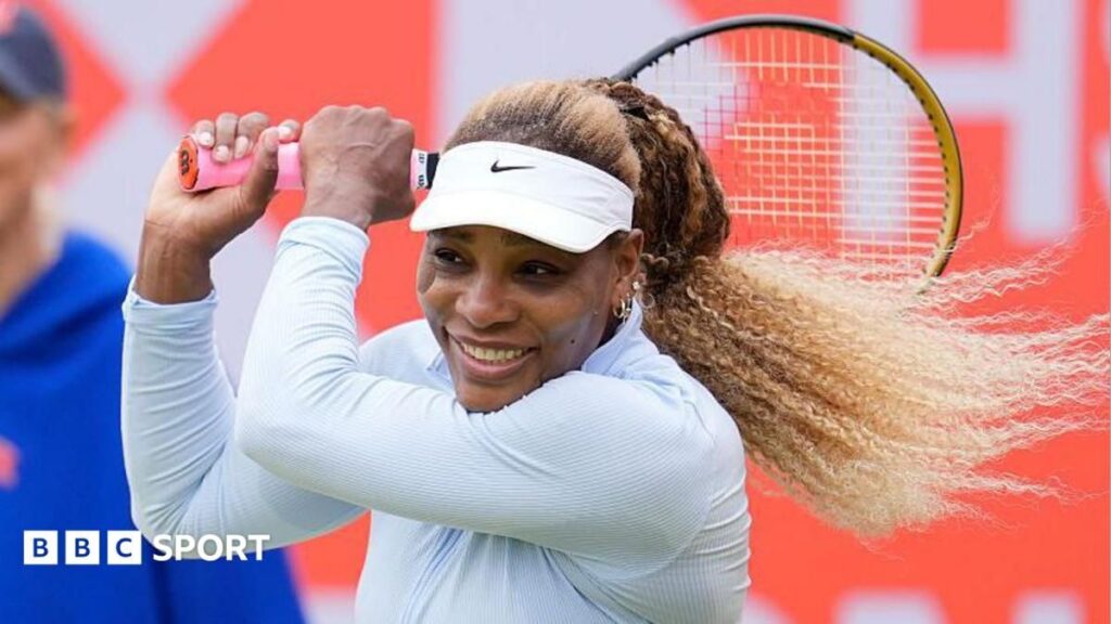 Serena Williams preparing to hit a shot on a grass tennis court