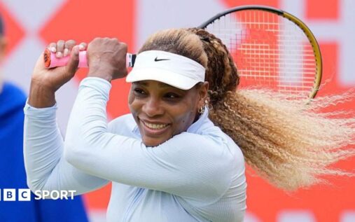 Serena Williams preparing to hit a shot on a grass tennis court