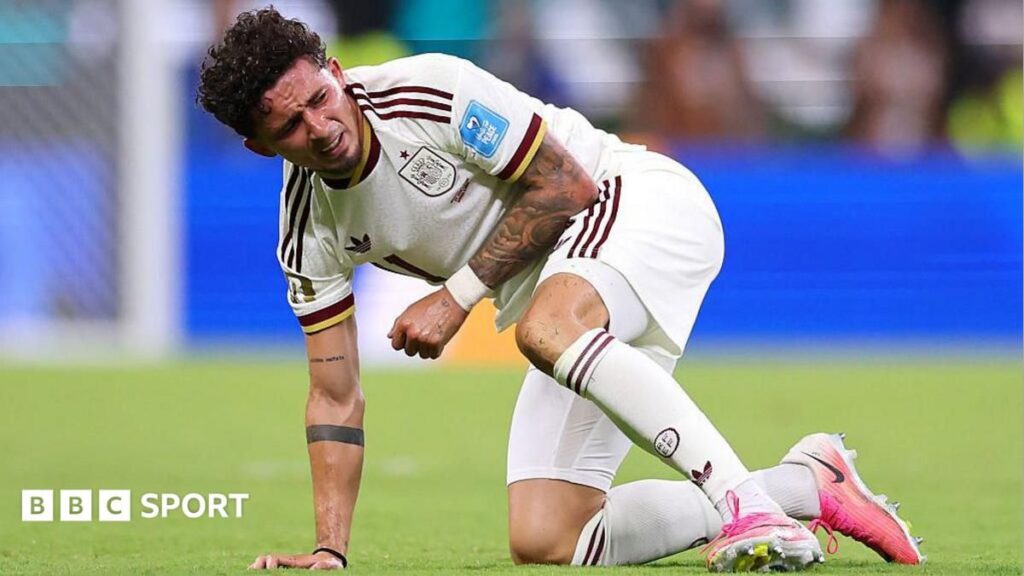 Spain winger Yeremy Pino holding his injured left shoulder in pain during the World Cup match against Uruguay