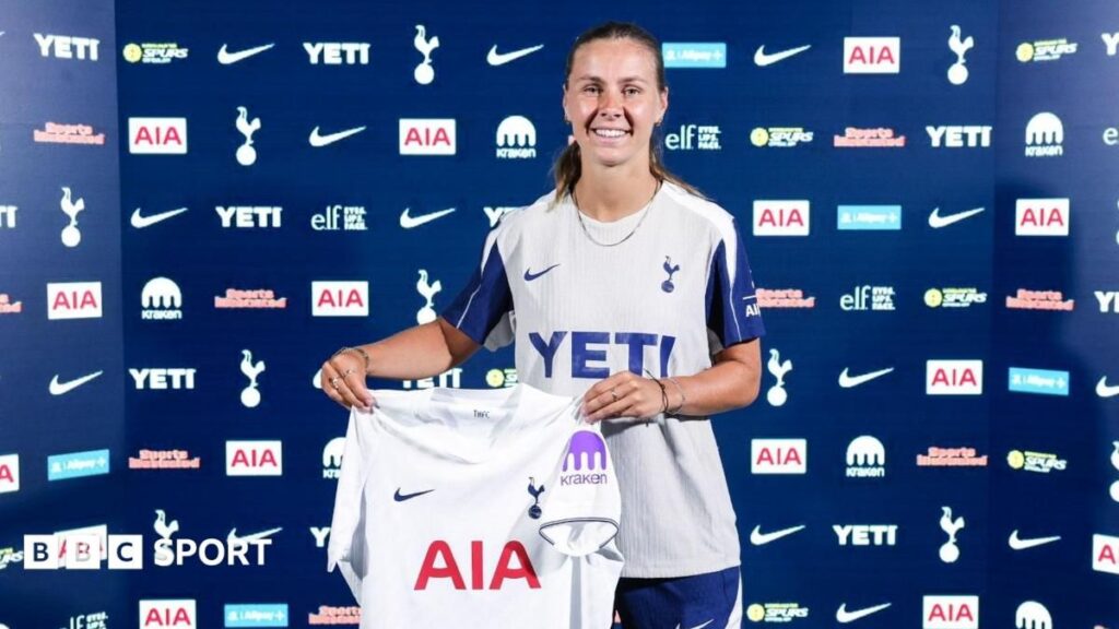 Victoria Pelova holding up a Tottenham Hotspur shirt after signing her new contract