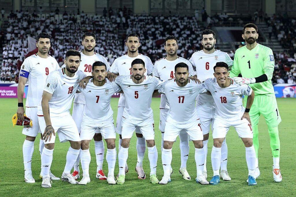 Iran national football team players lining up on the pitch before a match