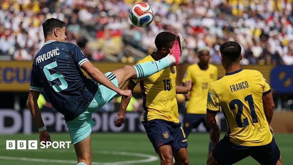 A football referee consulting the pitch-side VAR monitor during a World Cup match
