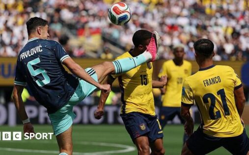 A football referee consulting the pitch-side VAR monitor during a World Cup match