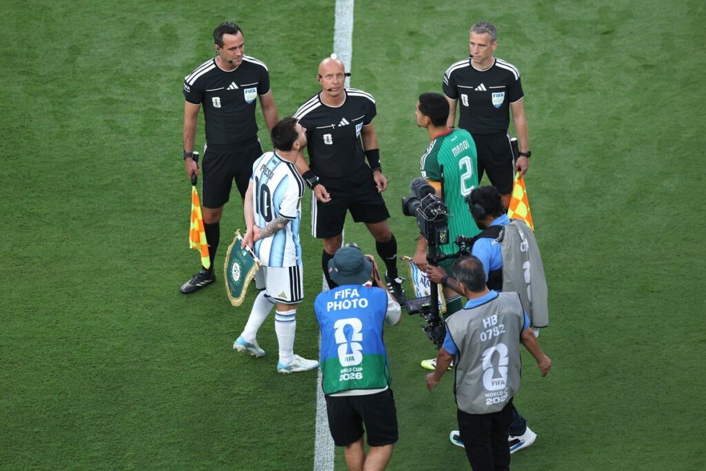 A football captain holding a special World Cup pennant bearing the slogan We Play Together We Stand Against Hate
