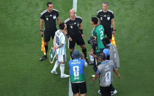 A football captain holding a special World Cup pennant bearing the slogan We Play Together We Stand Against Hate